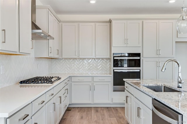 24563 E 34th Ave, Aurora, CO 80019 - kitchen with a sink, stainless steel appliances, light wood-style floors, wall chimney exhaust hood, and white cabinets