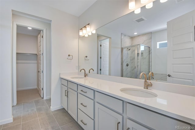 24563 E 34th Ave, Aurora, CO 80019 - full bathroom featuring a stall shower, double vanity, baseboards, a spacious closet, and tile patterned flooring