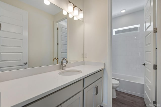 24563 E 34th Ave, Aurora, CO 80019 - full bathroom with toilet, wood finished floors, vanity, recessed lighting, and washtub / shower combination