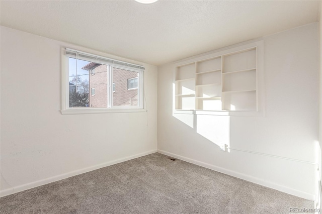 carpeted spare room featuring a textured ceiling