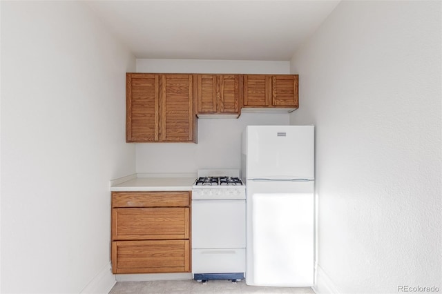 219 Terry St, Longmont, CO 80501 - kitchen featuring white appliances, brown cabinetry, and light countertops