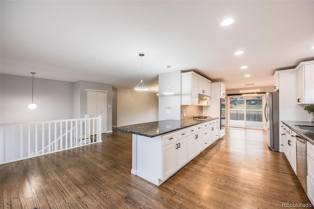 kitchen featuring decorative light fixtures, white cabinetry, and dark stone counters