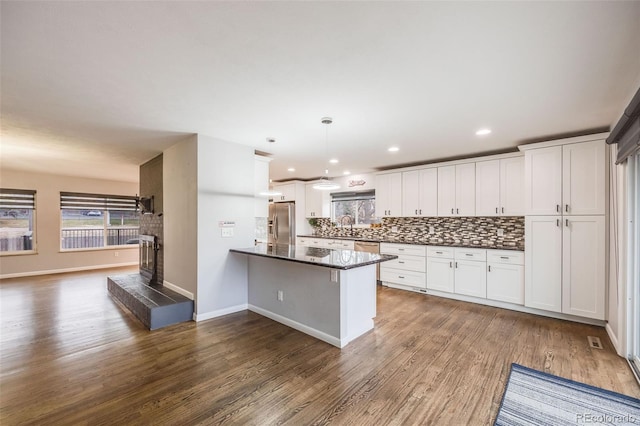 kitchen with hanging light fixtures, white cabinets, and stainless steel appliances