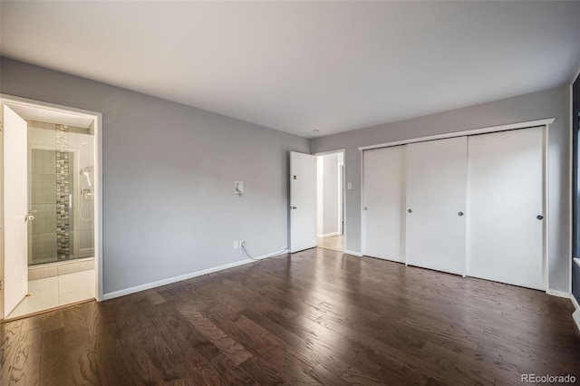 unfurnished bedroom with dark hardwood / wood-style flooring, ensuite bathroom, and a closet