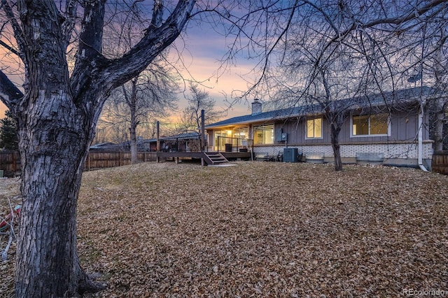 yard at dusk featuring a wooden deck and central AC