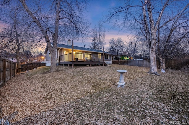 back house at dusk with a deck