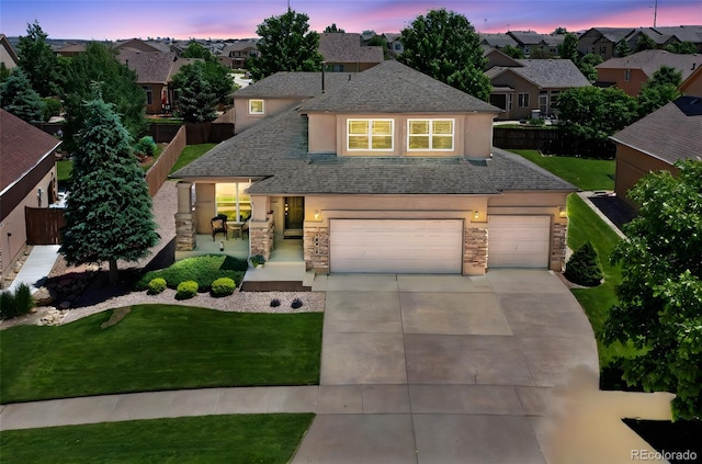 10643 Black Kettle Way, Colorado Springs, CO 80908 - traditional-style house featuring stone siding, stucco siding, driveway, roof with shingles, and an attached garage