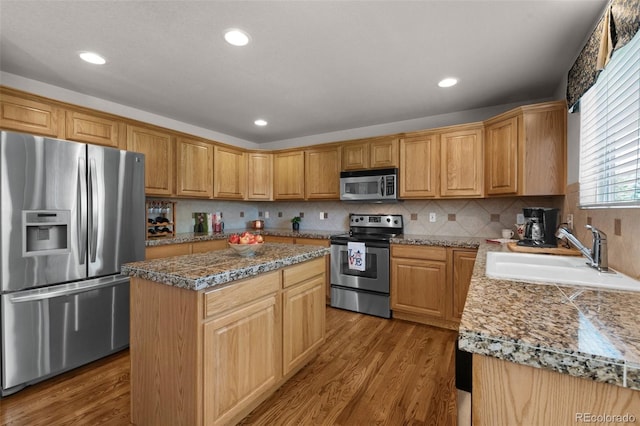 10643 Black Kettle Way, Colorado Springs, CO 80908 - kitchen with stainless steel appliances, wood finished floors, a center island, tasteful backsplash, and recessed lighting
