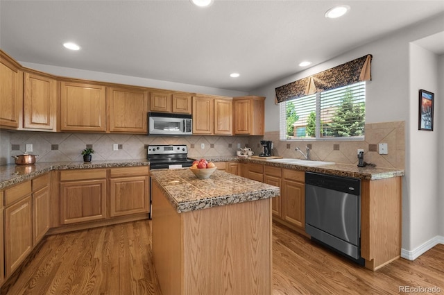 10643 Black Kettle Way, Colorado Springs, CO 80908 - kitchen with stainless steel appliances, tile countertops, light wood-type flooring, a kitchen island, and recessed lighting