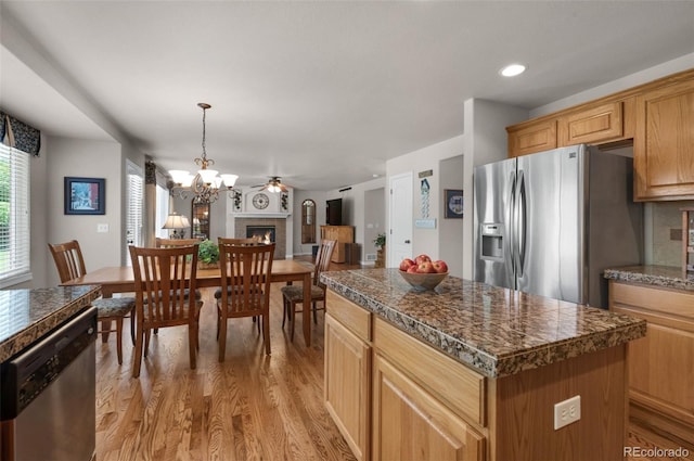 10643 Black Kettle Way, Colorado Springs, CO 80908 - kitchen with appliances with stainless steel finishes, tile countertops, light wood-type flooring, and a center island