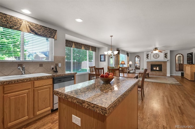 10643 Black Kettle Way, Colorado Springs, CO 80908 - kitchen with dishwasher, tile counters, a ceiling fan, light wood-style flooring, and a tiled fireplace