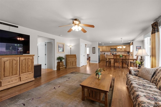10643 Black Kettle Way, Colorado Springs, CO 80908 - living room featuring wood finished floors, a ceiling fan, and a chandelier