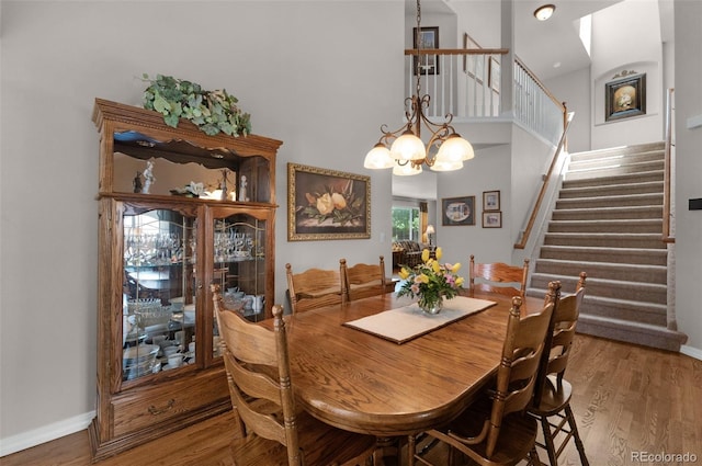 10643 Black Kettle Way, Colorado Springs, CO 80908 - dining space with stairway, wood finished floors, a chandelier, and a high ceiling