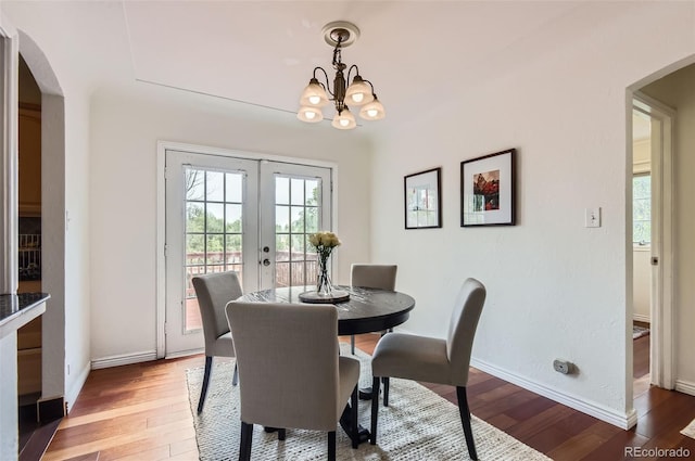 1697 W Powers Ave, Littleton, CO 80120 - dining area featuring arched walkways, light wood-style flooring, french doors, a chandelier, and baseboards