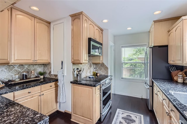 1697 W Powers Ave, Littleton, CO 80120 - kitchen with appliances with stainless steel finishes, light brown cabinets, dark wood finished floors, dark stone counters, and recessed lighting