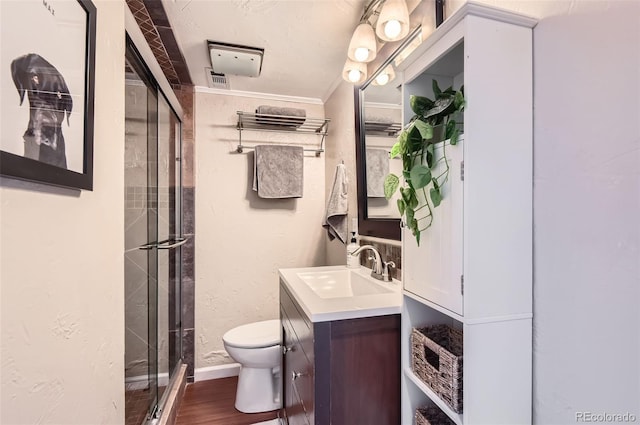 1697 W Powers Ave, Littleton, CO 80120 - bathroom featuring toilet, vanity, a stall shower, ornamental molding, and wood finished floors