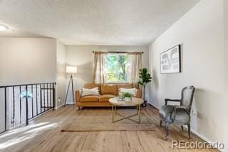 living area with hardwood / wood-style flooring and a textured ceiling