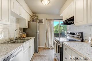 kitchen featuring white cabinets, decorative backsplash, stainless steel electric range oven, and sink