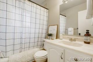 bathroom with vanity, toilet, and curtained shower