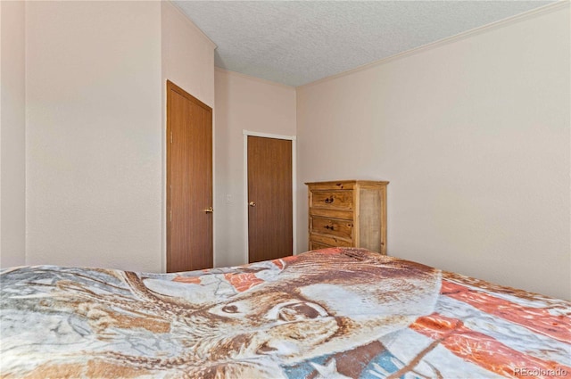 bedroom featuring crown molding and a textured ceiling