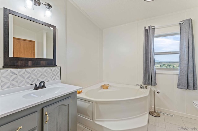 bathroom with backsplash, tile patterned floors, a washtub, vanity, and toilet