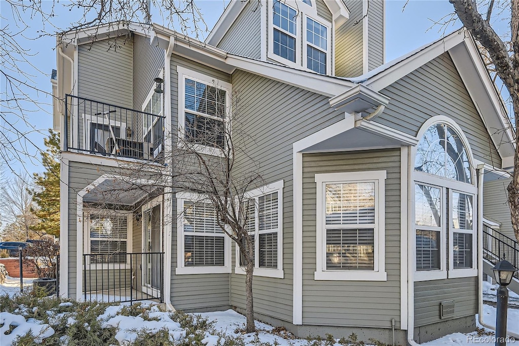 view of snow covered exterior with a balcony