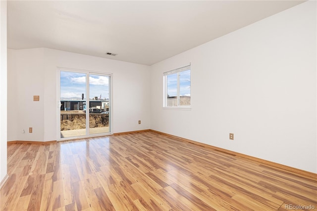 empty room featuring light hardwood / wood-style floors and plenty of natural light