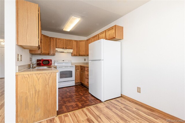 kitchen with sink, dark hardwood / wood-style floors, and white appliances