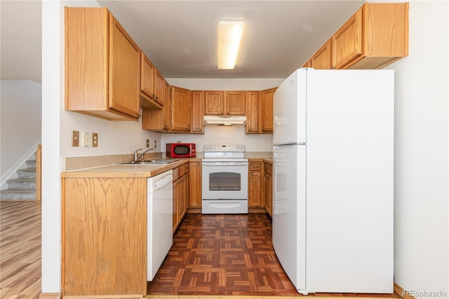 kitchen with dark parquet flooring, sink, and white appliances