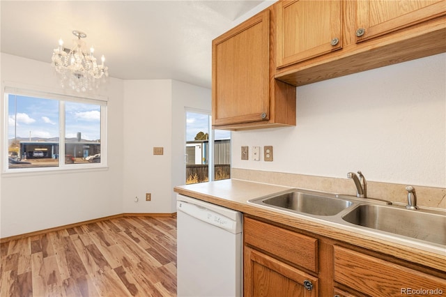 kitchen with light wood-type flooring, white dishwasher, sink, decorative light fixtures, and an inviting chandelier