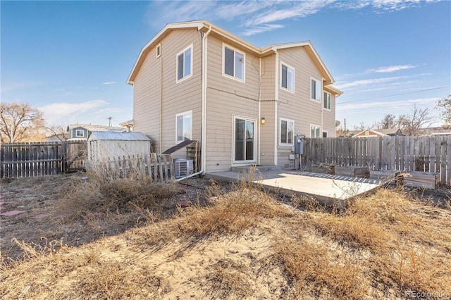 rear view of property featuring a patio and a storage shed