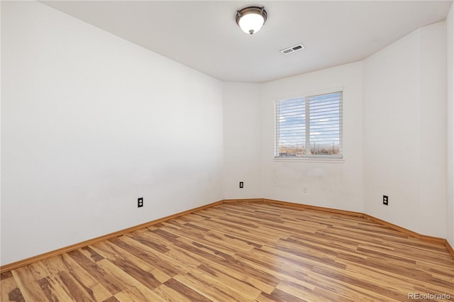 empty room with light hardwood / wood-style flooring