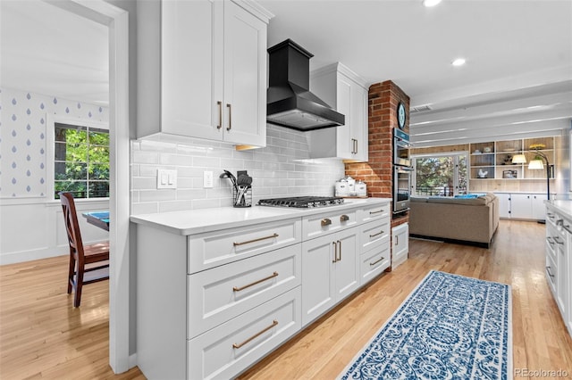 5465 W Ontario Ave, Littleton, CO 80128 - kitchen featuring wall chimney exhaust hood, light wood-type flooring, light countertops, a wainscoted wall, and recessed lighting