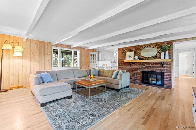 5465 W Ontario Ave, Littleton, CO 80128 - living room featuring light wood finished floors, beam ceiling, a fireplace, and wooden walls