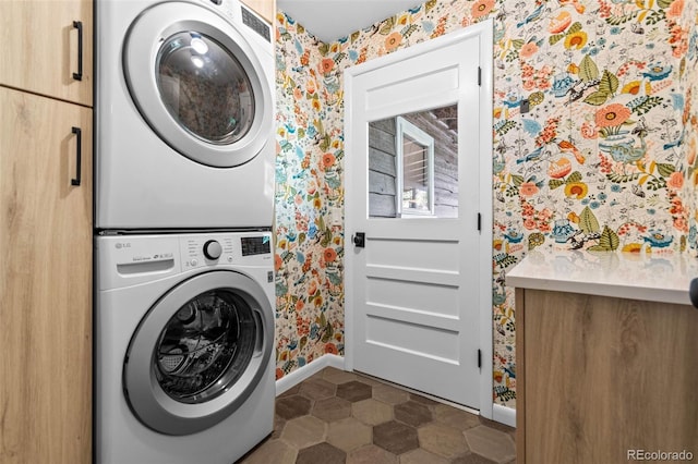5465 W Ontario Ave, Littleton, CO 80128 - laundry area featuring wallpapered walls, stacked washer / dryer, cabinet space, and dark tile patterned flooring