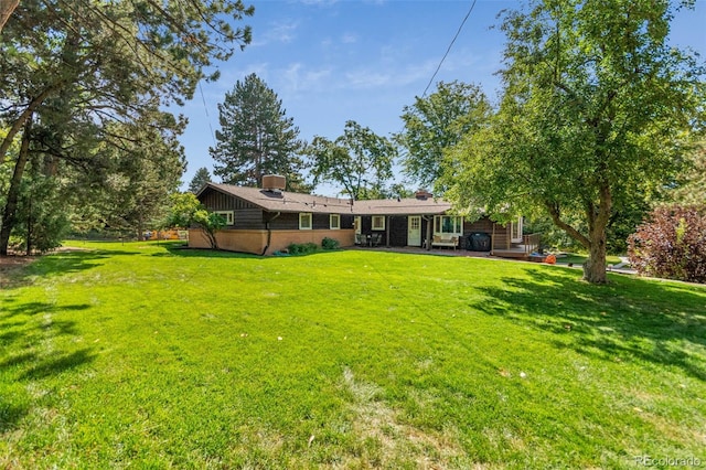 5465 W Ontario Ave, Littleton, CO 80128 - back of property with a yard, a chimney, and a patio area