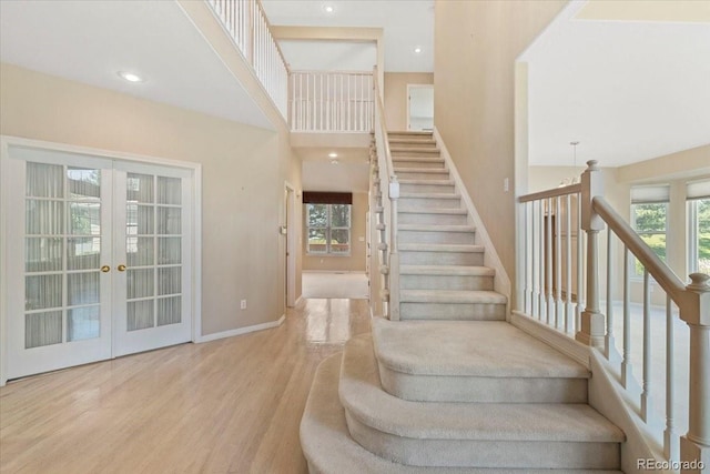 6449 S Jamaica Cir, Englewood, CO 80111 - staircase with wood finished floors, a high ceiling, and french doors