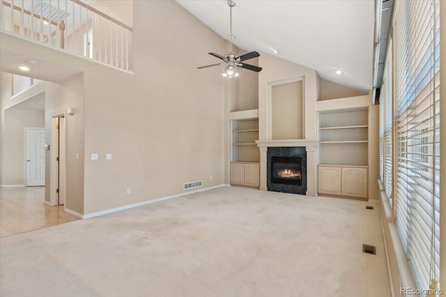 6449 S Jamaica Cir, Englewood, CO 80111 - unfurnished living room with high vaulted ceiling, a glass covered fireplace, carpet, a ceiling fan, and built in shelves