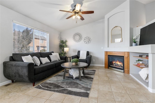 living room with a glass covered fireplace, a healthy amount of sunlight, baseboards, and light tile patterned floors