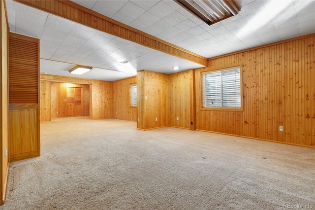 carpeted empty room with wood walls