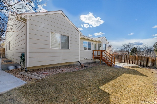 view of side of property featuring a lawn and fence