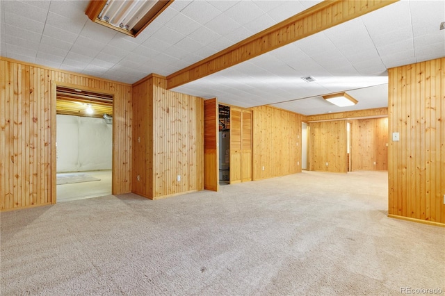 finished below grade area with water heater, carpet, and wooden walls