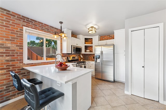 561 James St, Highlands Ranch, CO 80126 - kitchen featuring stainless steel appliances, a peninsula, white cabinetry, light tile patterned floors, and light countertops