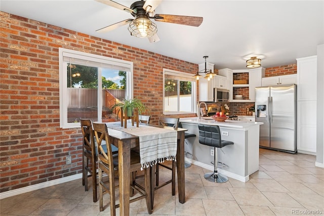 561 James St, Highlands Ranch, CO 80126 - dining room with brick wall, a ceiling fan, and light tile patterned floors
