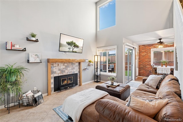 561 James St, Highlands Ranch, CO 80126 - tiled living room featuring ceiling fan, a brick fireplace, and a towering ceiling
