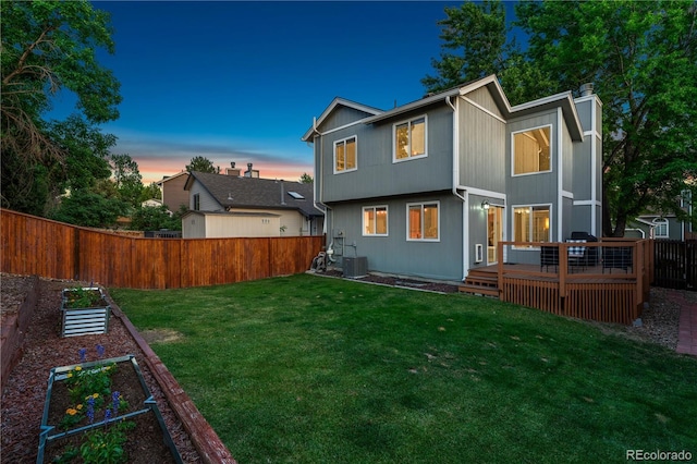 561 James St, Highlands Ranch, CO 80126 - back of property at dusk featuring a garden, a fenced backyard, a wooden deck, and a chimney