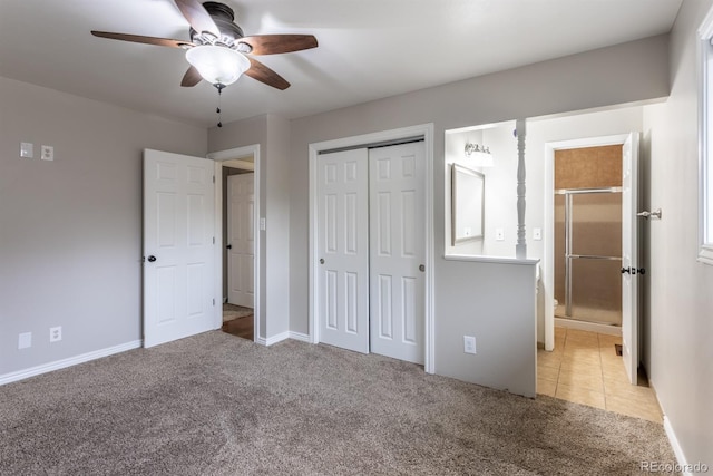 unfurnished bedroom with a ceiling fan, light colored carpet, a closet, and ensuite bathroom