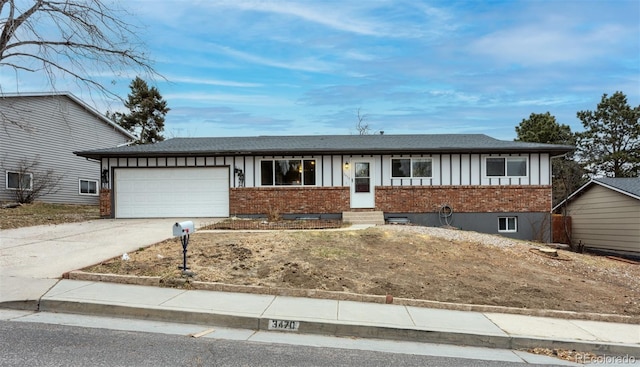 ranch-style house with brick siding, an attached garage, board and batten siding, and driveway