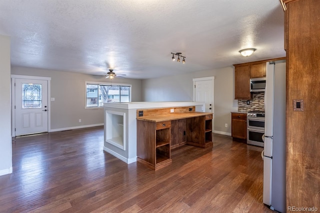 kitchen with brown cabinets, open shelves, stainless steel appliances, decorative backsplash, and dark wood-style flooring