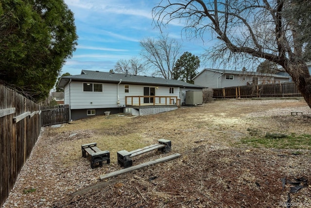 rear view of house with a fenced backyard and a deck